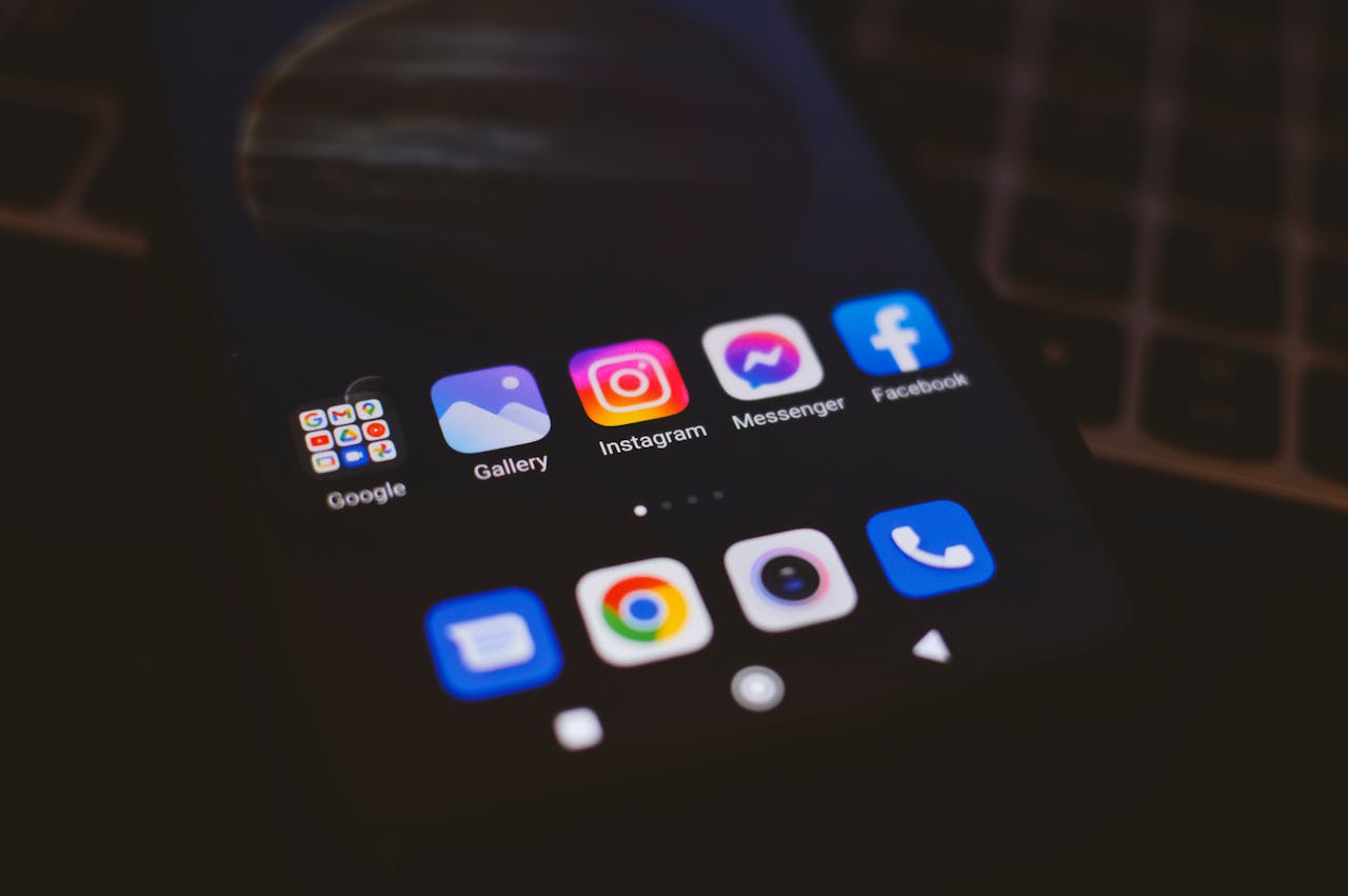 A smartphone displaying popular social media apps in a dimly lit environment, perfect for tech and communication themes.